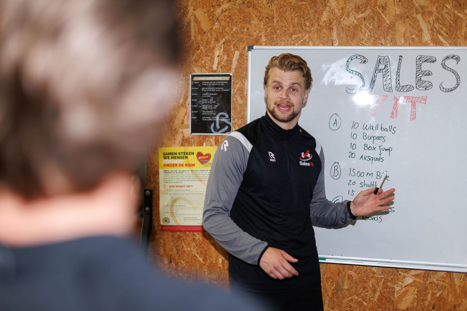 Wim licht de workout toe op het whiteboard in de CrossFit-gym