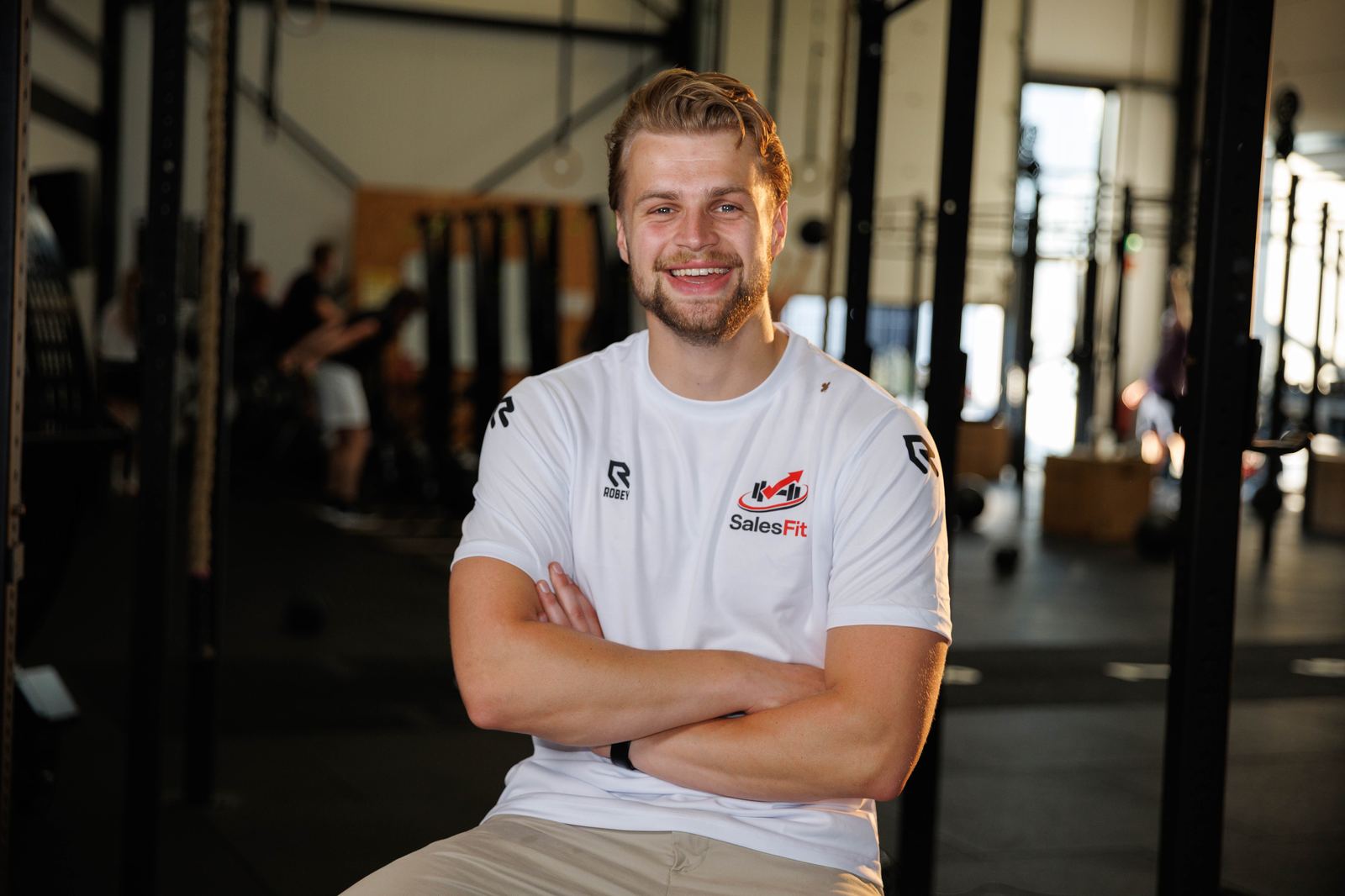 Portret van Wim Pot met laptop en dumbbell in de CrossFit-gym